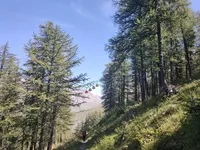Les télécabines qui passent au dessus du chemin avec un randonneur - © Elodie LEFEBVRE