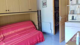 Salon : canapé-lit et coin cuisine - © Petitcolas Patricia