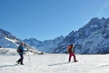Hikers snowshoe in front of the peaks of the Ecrins - © Bertrand Boone